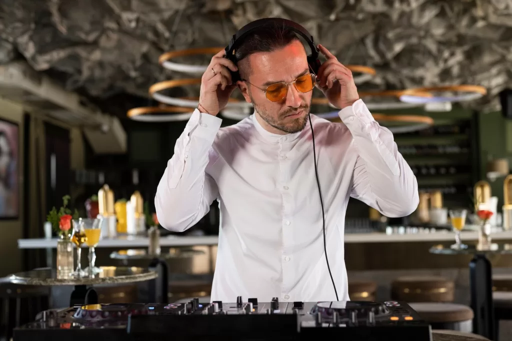 DJ animant la piste de danse lors d'une réception de mariage, avec des lumières colorées et une foule d'invités dansant