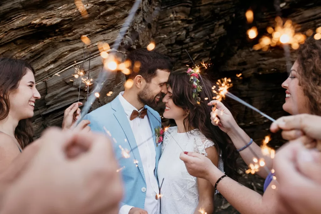 Couple de mariés s'échangeant leurs vœux dans un cadre enchanteur, entouré de fleurs et d'invités.